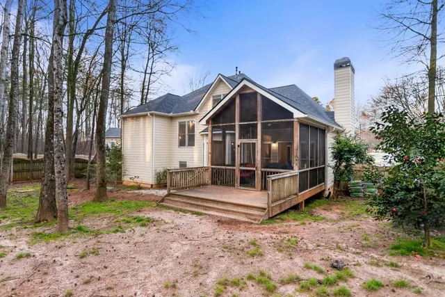 a view of a house with a yard and wooden fence