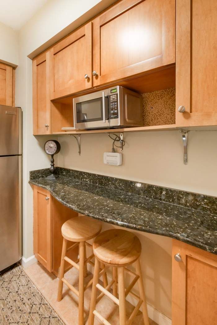 305 East 72nd Street, Unit 5AS Manhattan, NY 10021 - Photo 6 of 11 a kitchen with stainless steel appliances granite countertop a sink and a refrigerator