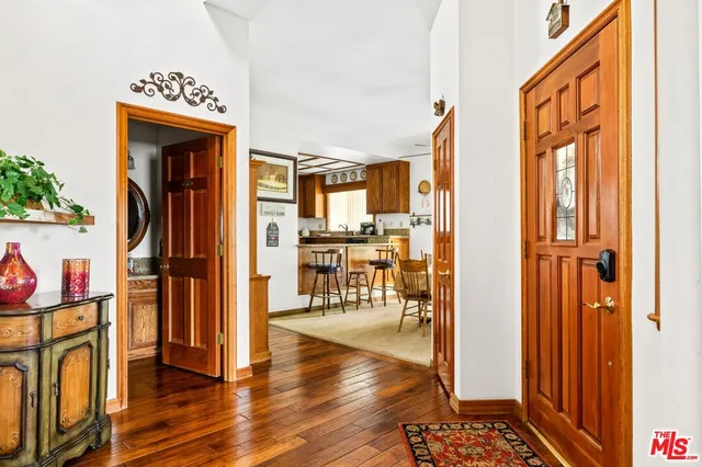 a view of a hallway with wooden floor and dining room