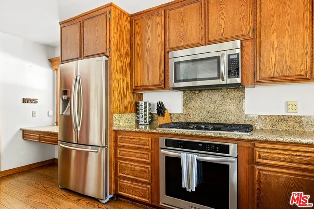 a kitchen with stainless steel appliances granite countertop a refrigerator stove and microwave