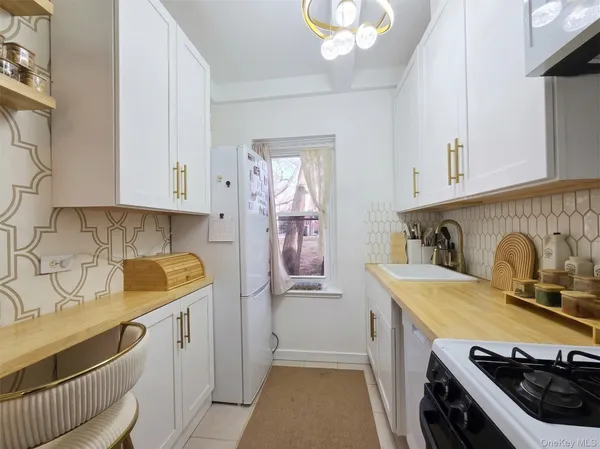 a kitchen with stainless steel appliances granite countertop a sink stove refrigerator and cabinets