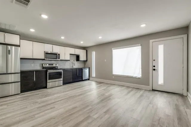 a large kitchen with stainless steel appliances granite countertop a stove a sink and a refrigerator