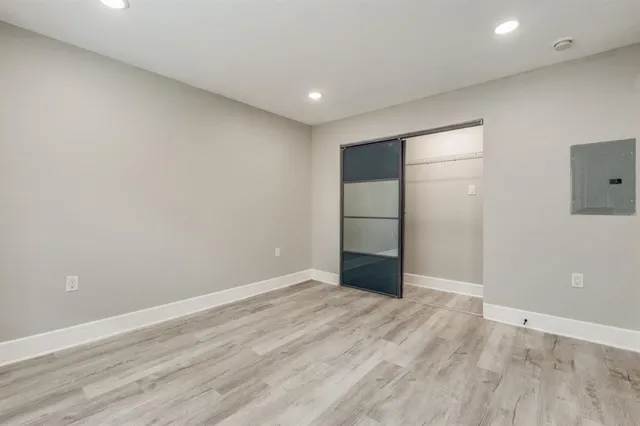 an empty room with wooden floor and natural light