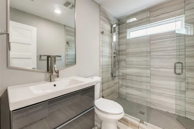 a bathroom with a shower a toilet and a sink