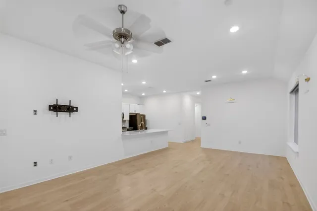a view of a kitchen with a sink hardwood floor and a ceiling fan