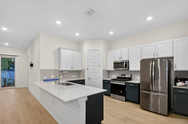 a kitchen with refrigerator and cabinets