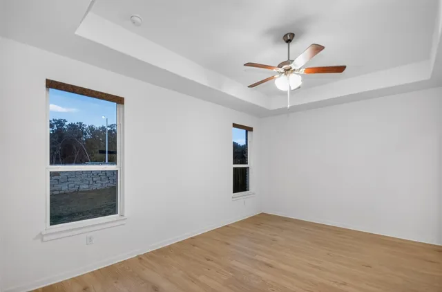 a view of an empty room with a window and a ceiling fan