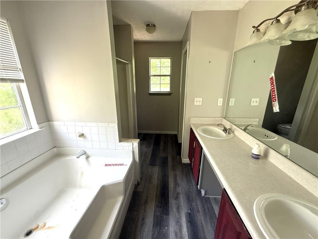 7251 Williams Road Flowery Branch, GA 30542 - Photo 7 of 10 a en suite bathroom with a granite countertop sink and a large mirror