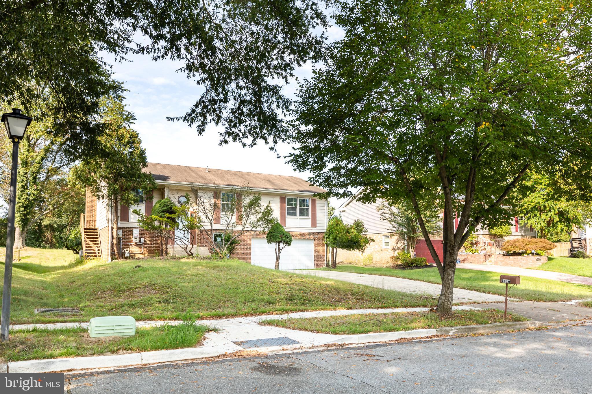 1116 Kings Tree Drive Bowie, MD 20721 - Photo 9 of 15 a view of a big house with large trees and a big yard