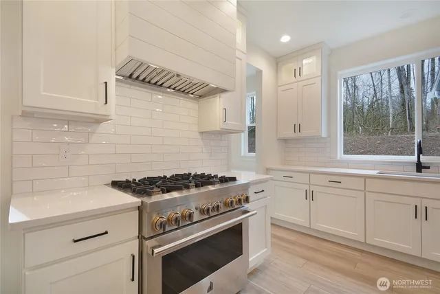 a kitchen with granite countertop a stove sink and cabinets