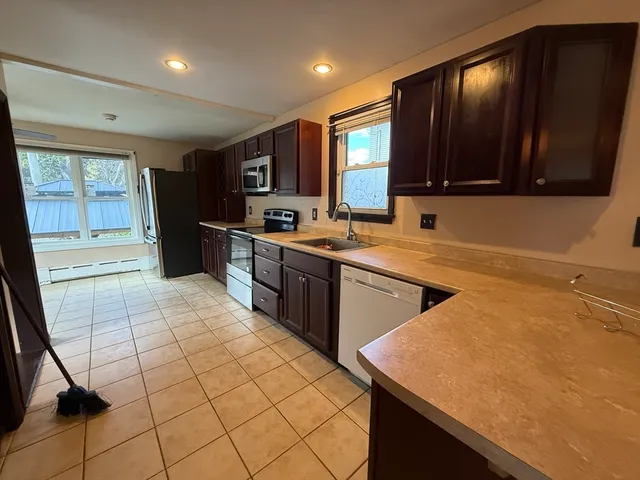 a kitchen with a sink a stove cabinets and a counter top space
