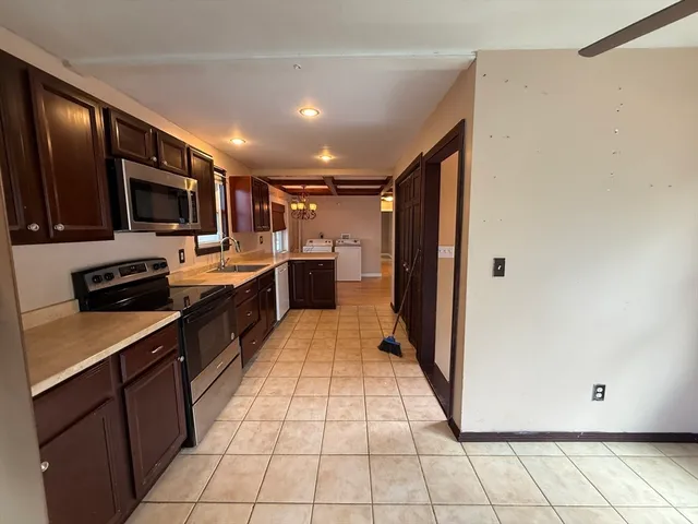 a large kitchen with stainless steel appliances lots of counter top space