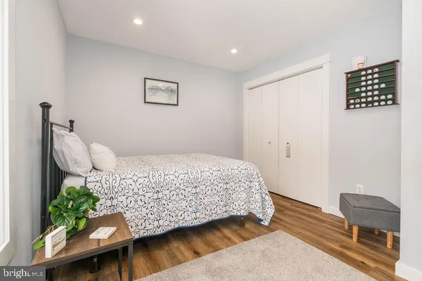 a bedroom with a bed and a chair with the wooden floor