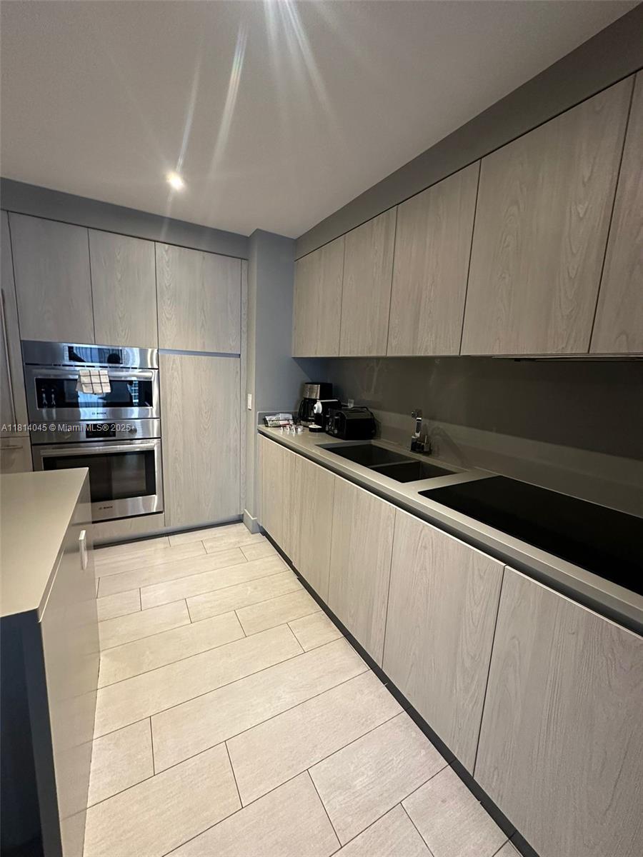 4010 South Ocean Drive, Unit R1507 Hollywood, FL 33019 - Photo 5 of 14 a kitchen with stainless steel appliances a sink a stove a microwave a sink a refrigerator and cabinets