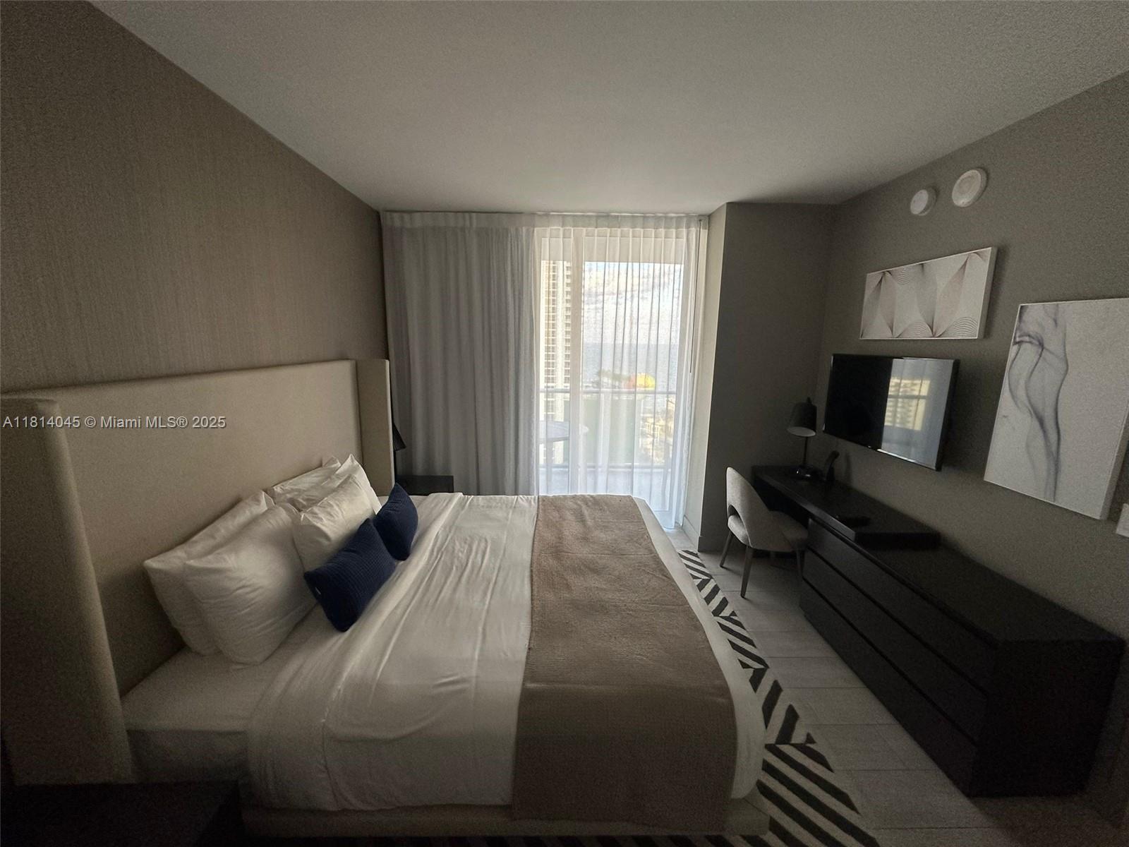 4010 South Ocean Drive, Unit R1507 Hollywood, FL 33019 - Photo 6 of 14 a bedroom with a bed and wooden floor