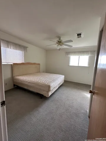 a bed sitting in a bedroom next to a window