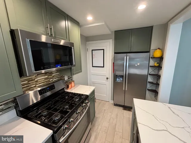 a kitchen with stainless steel appliances a refrigerator and a stove top oven