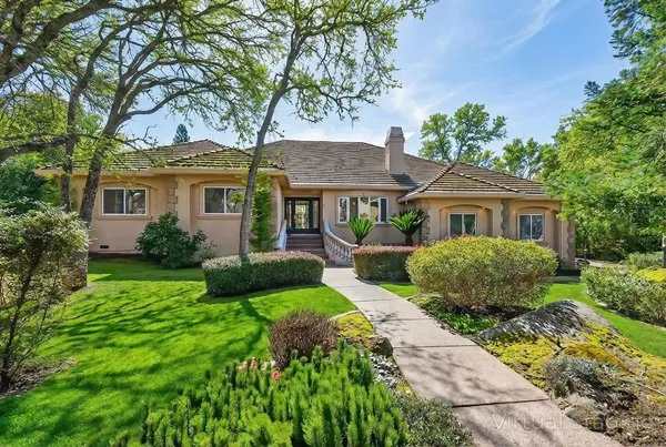 a front view of a house with a yard and potted plants