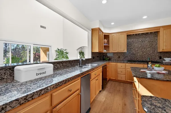 a kitchen with stainless steel appliances granite countertop a sink stove and cabinets
