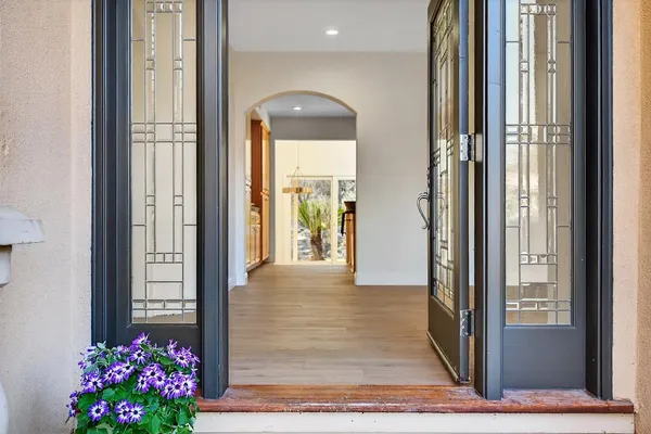 a view of a hallway with wooden floor and front door
