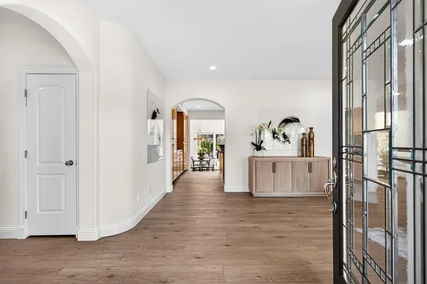 a view of a hallway with wooden floor and entryway
