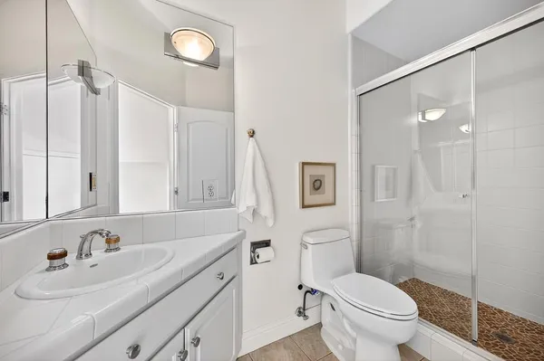 a bathroom with a double vanity sink a toilet and a mirror
