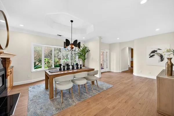 a dining room with furniture a chandelier and wooden floor