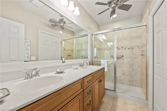 a bathroom with a granite countertop sink a mirror a vanity and shower