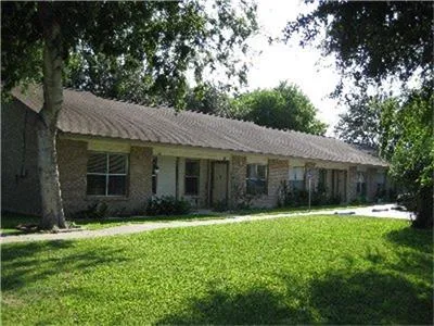 a front view of a house with a yard and trees