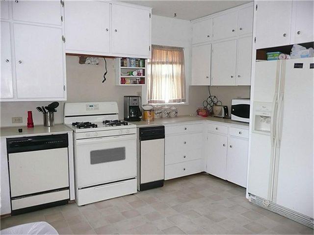 519 North Main Street Donna, TX 78537 - Photo 3 of 6 a kitchen with white cabinets and white appliances