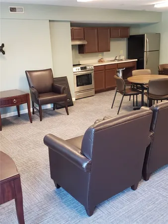a living room with stainless steel appliances kitchen island granite countertop furniture and a kitchen view