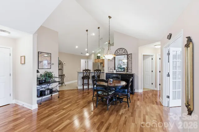 a view of a dining room and livingroom with furniture wooden floor a chandelier