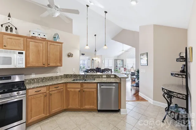 a kitchen with granite countertop a stove sink and cabinets