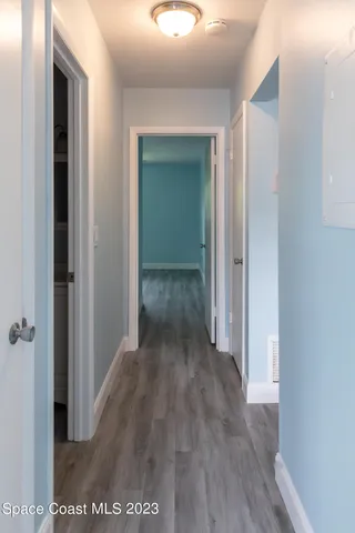 a view of a hallway with wooden floor