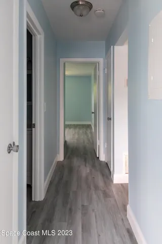 a view of a hallway with wooden floor