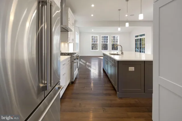 a kitchen with kitchen island granite countertop lots of counter top space and wooden floor