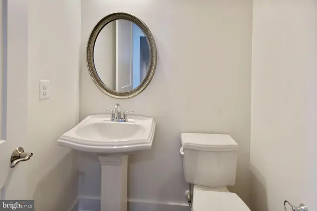 a bathroom with a sink a toilet and a mirror