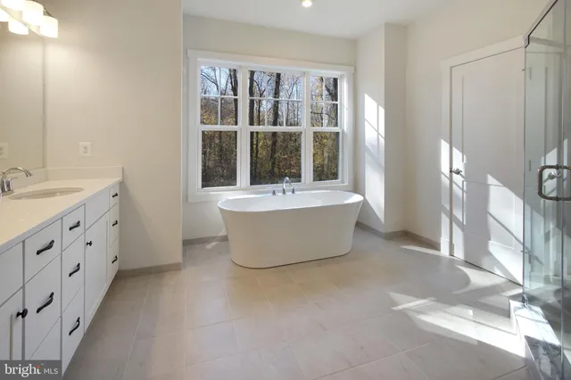 a bathroom with a tub sink and mirror