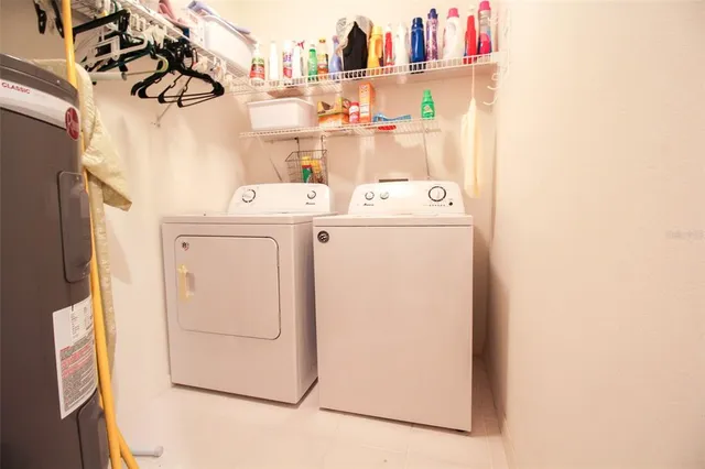 a kitchen with stainless steel appliances kitchen island granite countertop a dining table chairs and a refrigerator