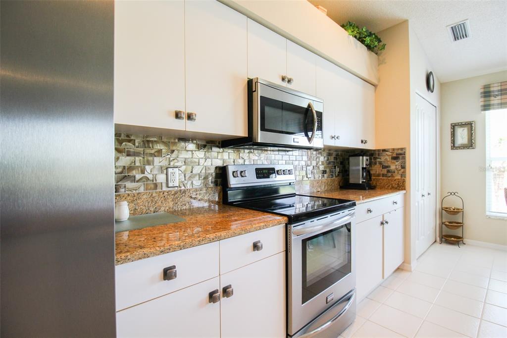 5301 Mahogany Run Avenue, Unit 1023 Sarasota, FL 34241 - Photo 37 of 56 a kitchen with stainless steel appliances granite countertop a sink stove and microwave