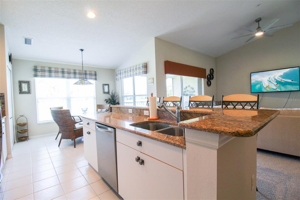 5301 Mahogany Run Avenue, Unit 1023 Sarasota, FL 34241 - Photo 38 of 56 a kitchen with stainless steel appliances granite countertop a sink and a white cabinets