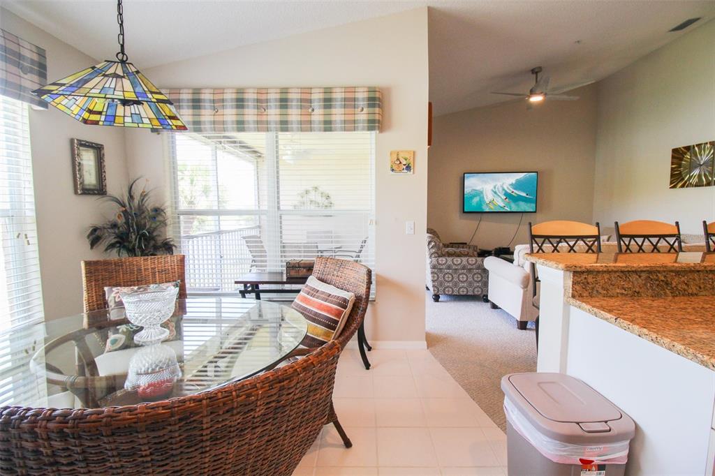 5301 Mahogany Run Avenue, Unit 1023 Sarasota, FL 34241 - Photo 43 of 56 a living room with furniture a floor to ceiling window and a flat screen tv