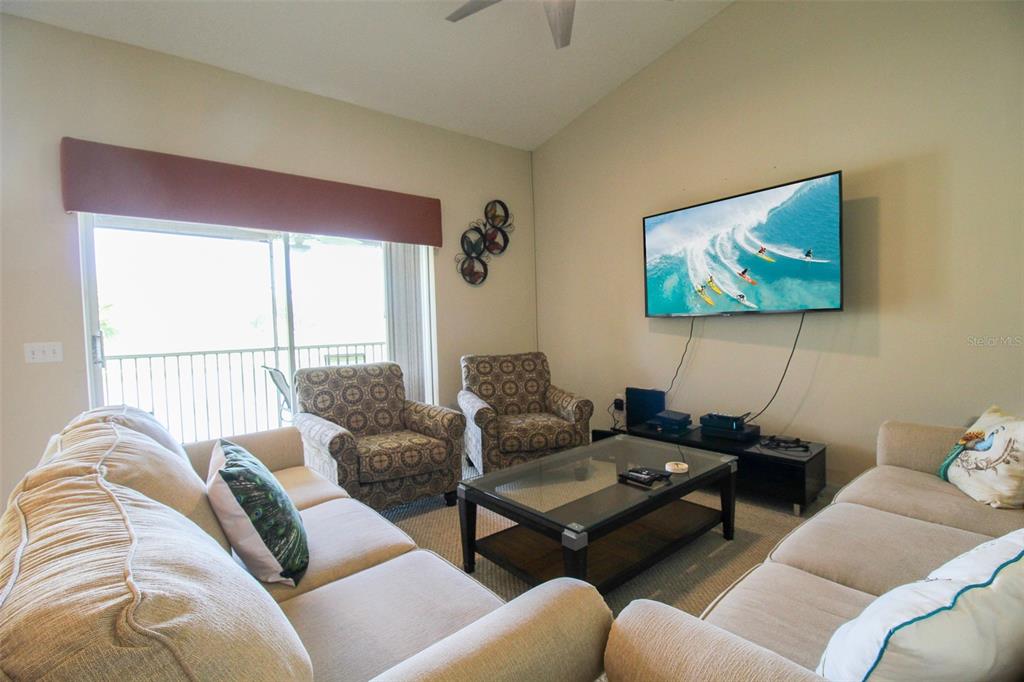 5301 Mahogany Run Avenue, Unit 1023 Sarasota, FL 34241 - Photo 47 of 56 a living room with furniture a couch and a flat screen tv