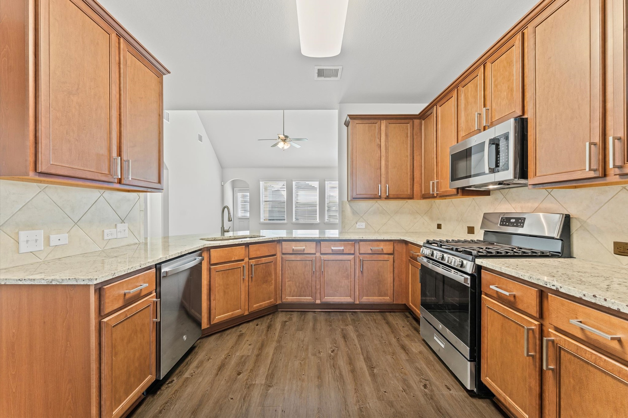 15207 Lake Erie Drive Humble, TX 77396 - Photo 5 of 37 a kitchen with stainless steel appliances granite countertop wooden cabinets a sink and a stove