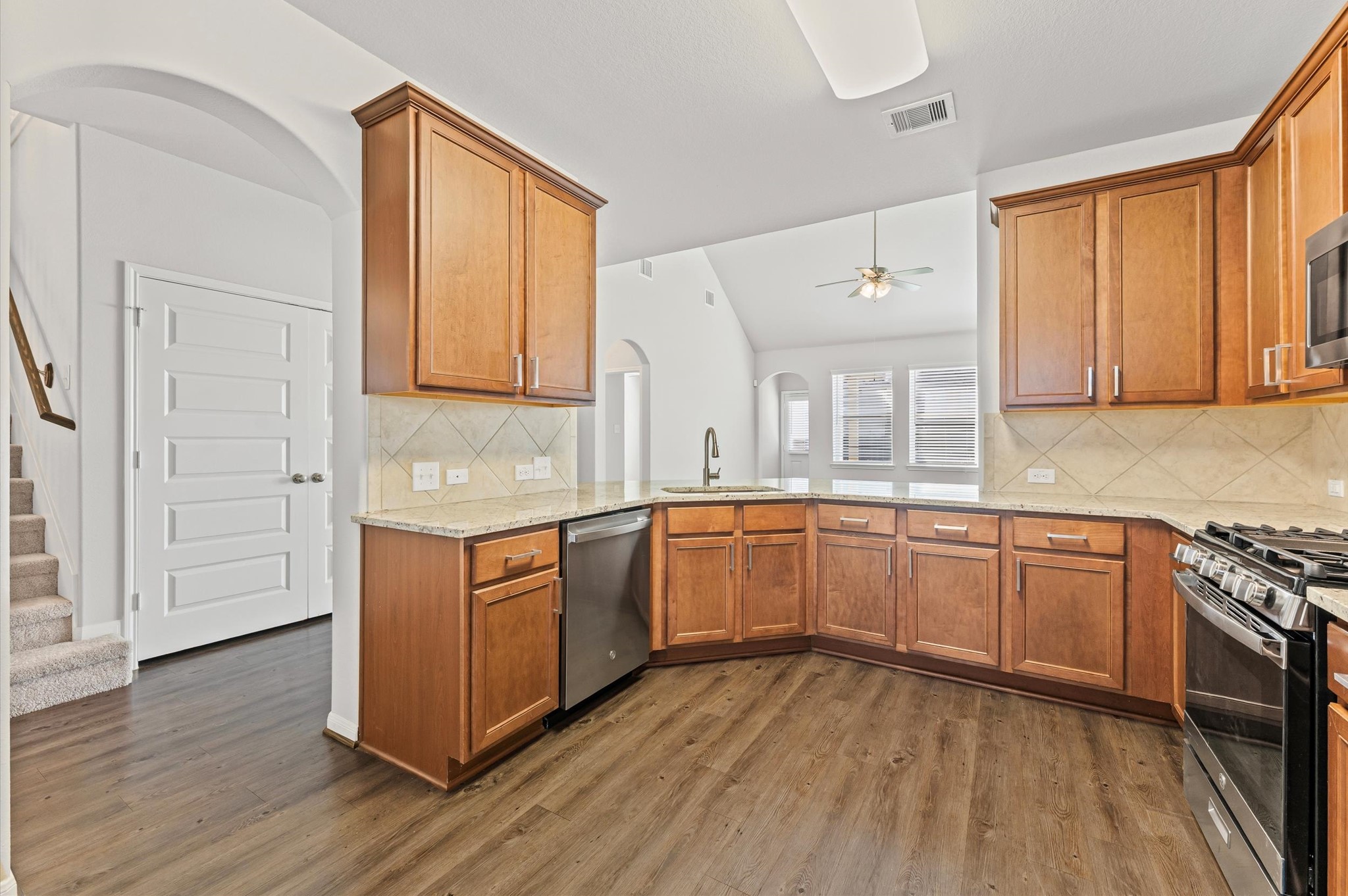 15207 Lake Erie Drive Humble, TX 77396 - Photo 6 of 37 a kitchen with granite countertop wooden floors and white cabinets