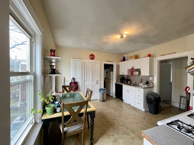 a living room with furniture and a dining table with kitchen view