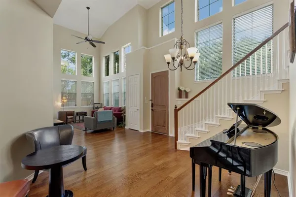 a view of a livingroom with furniture stairs wooden floor and windows