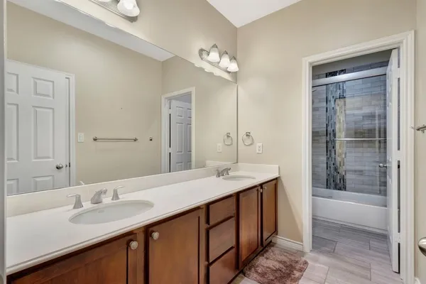 a bathroom with a granite countertop sink a mirror and a shower