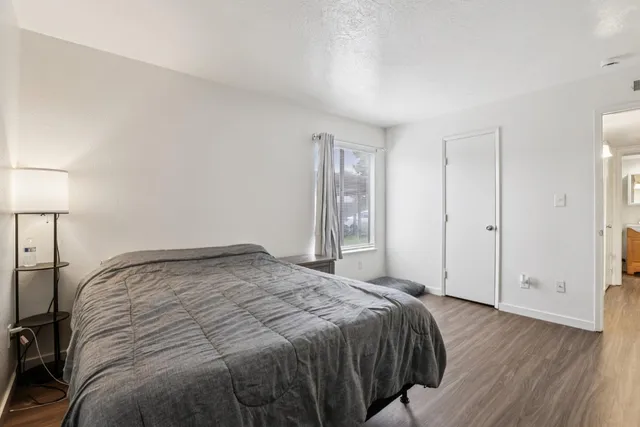 a bedroom with a bed and wooden floor