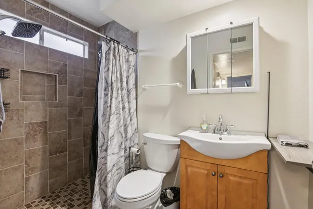 a bathroom with a sink a toilet and shower